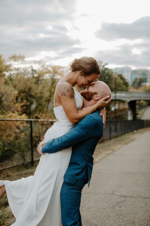 Romantic moment between newlyweds embracing on an outdoor pathway.