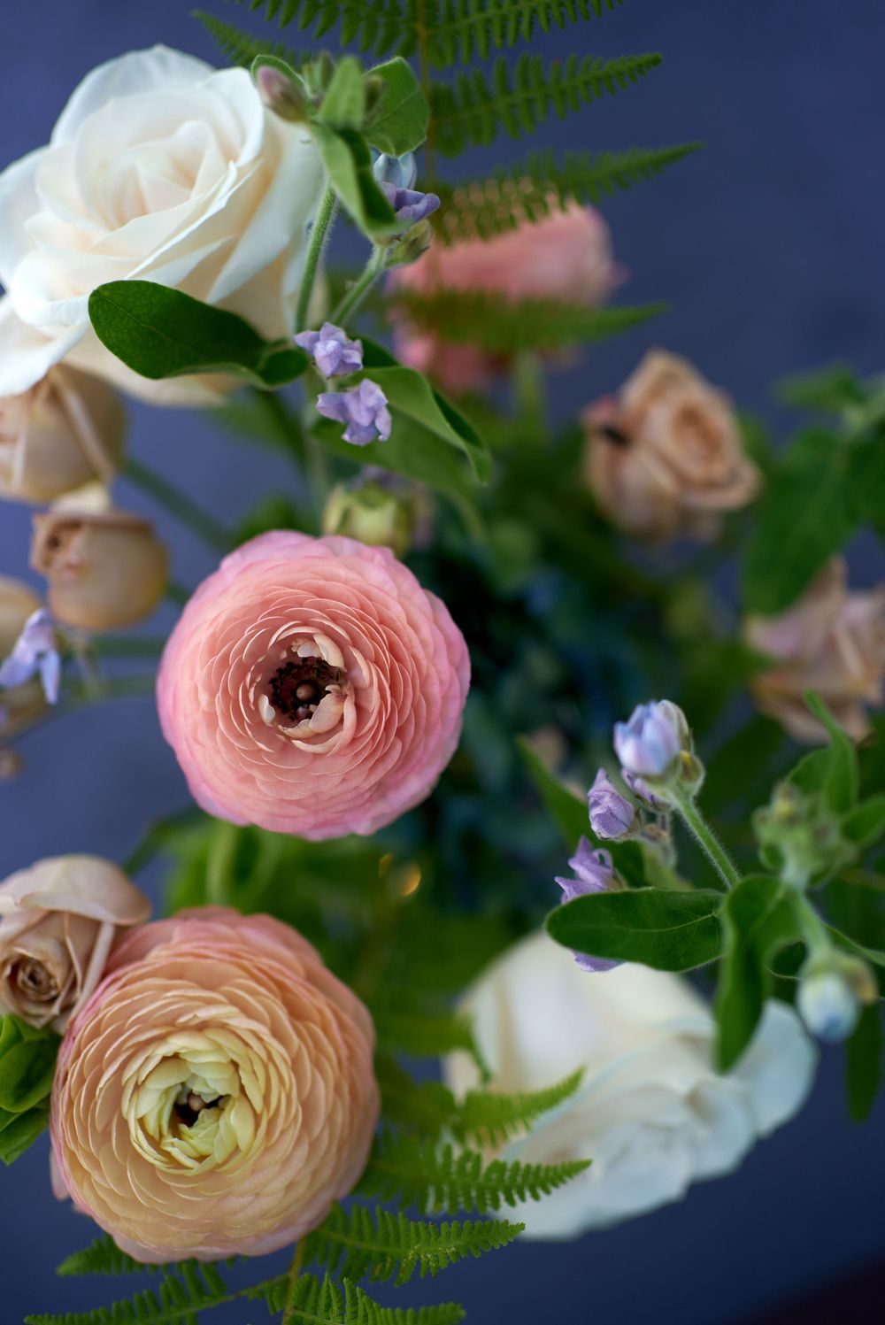 Ethereal white roses and apricot ranunculus blooms highlight a bridal bouquet