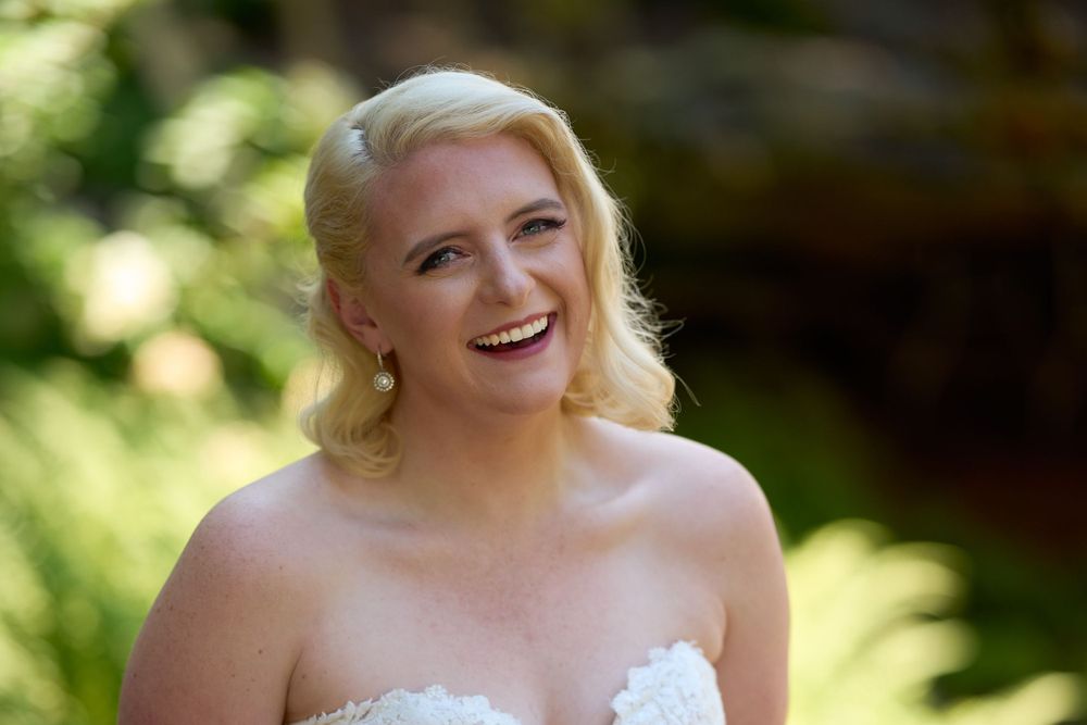Blonde woman in strapless wedding gown smiles broadly