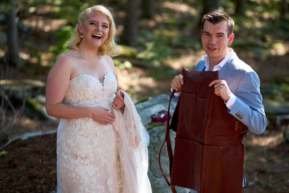 Glamourous blonde bride laughs as groom shows off his groom's gift