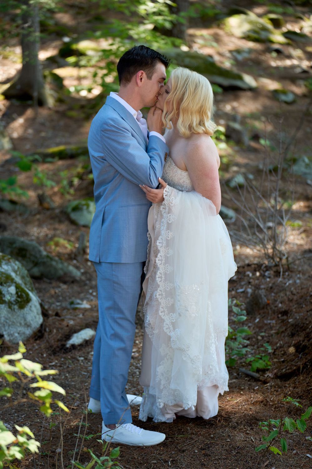 A romantic embrace and kiss between bride and groom woodland setting Squam Lake