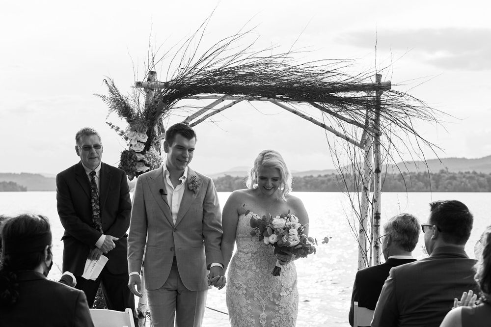 Just after the wedding ceremony bride and groom recede down Squam Lake pier