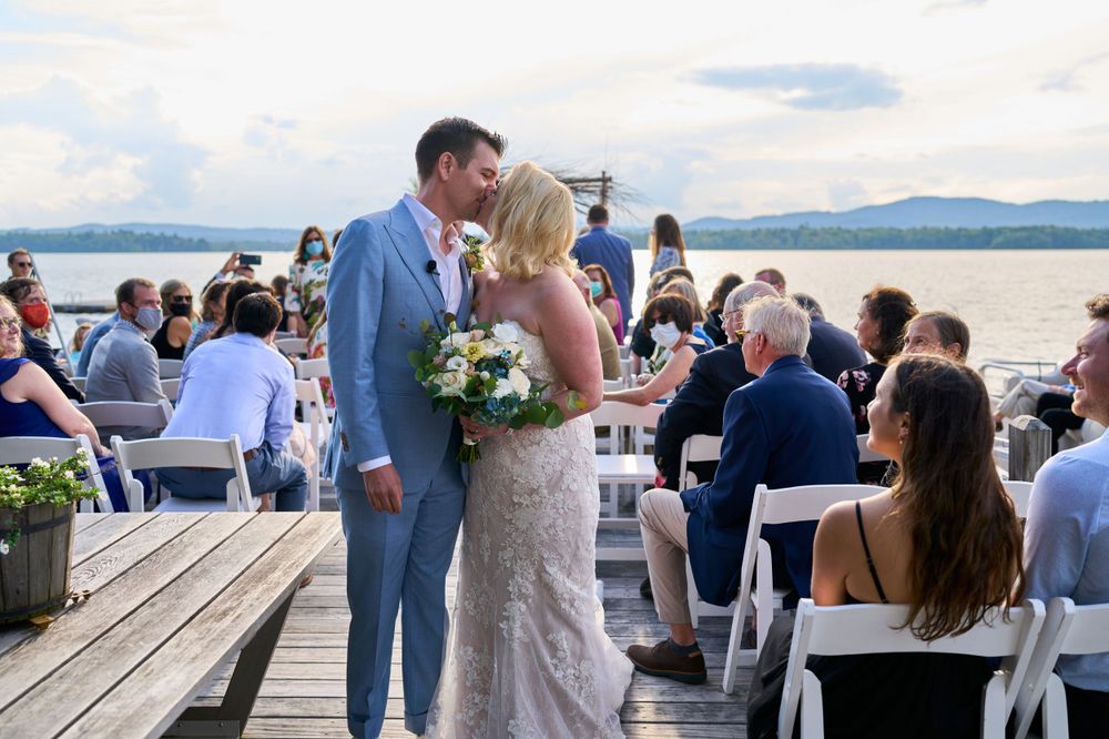 Bride and groom share a kiss as they recede down Squam Lake pier