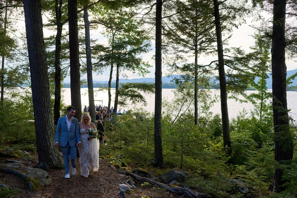 Magnificent evergreen trees surround newlyweds by Squam Lake