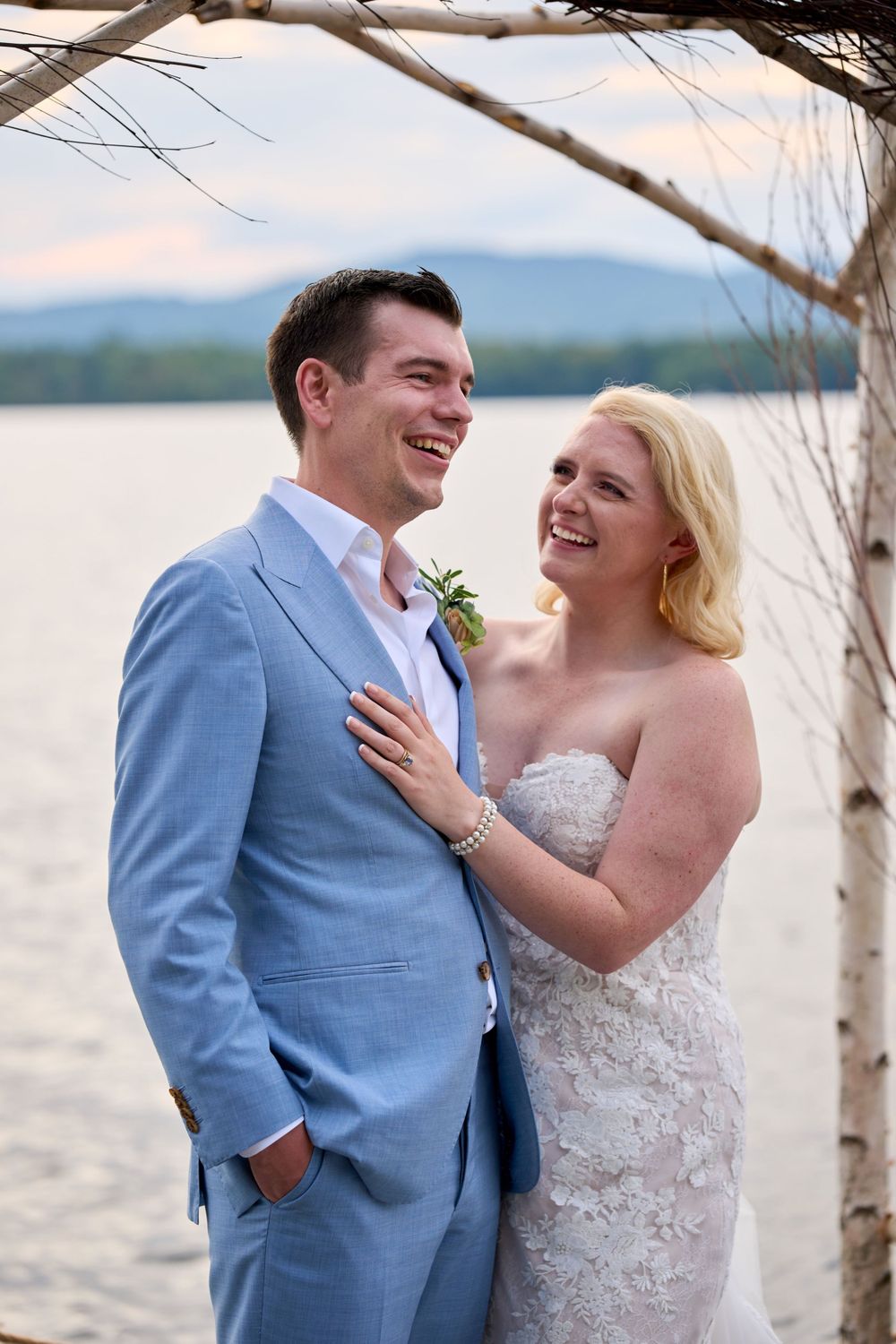 Groom shares a laugh with his smiling bride Squam Lake