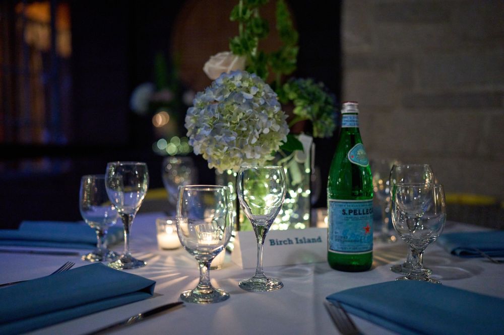Wine glasses in candlelight atop wedding reception table