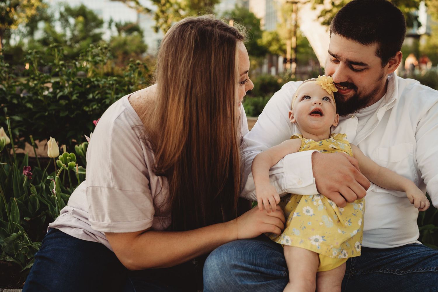 Happy family sharing playful moment together outdoors in garden setting.