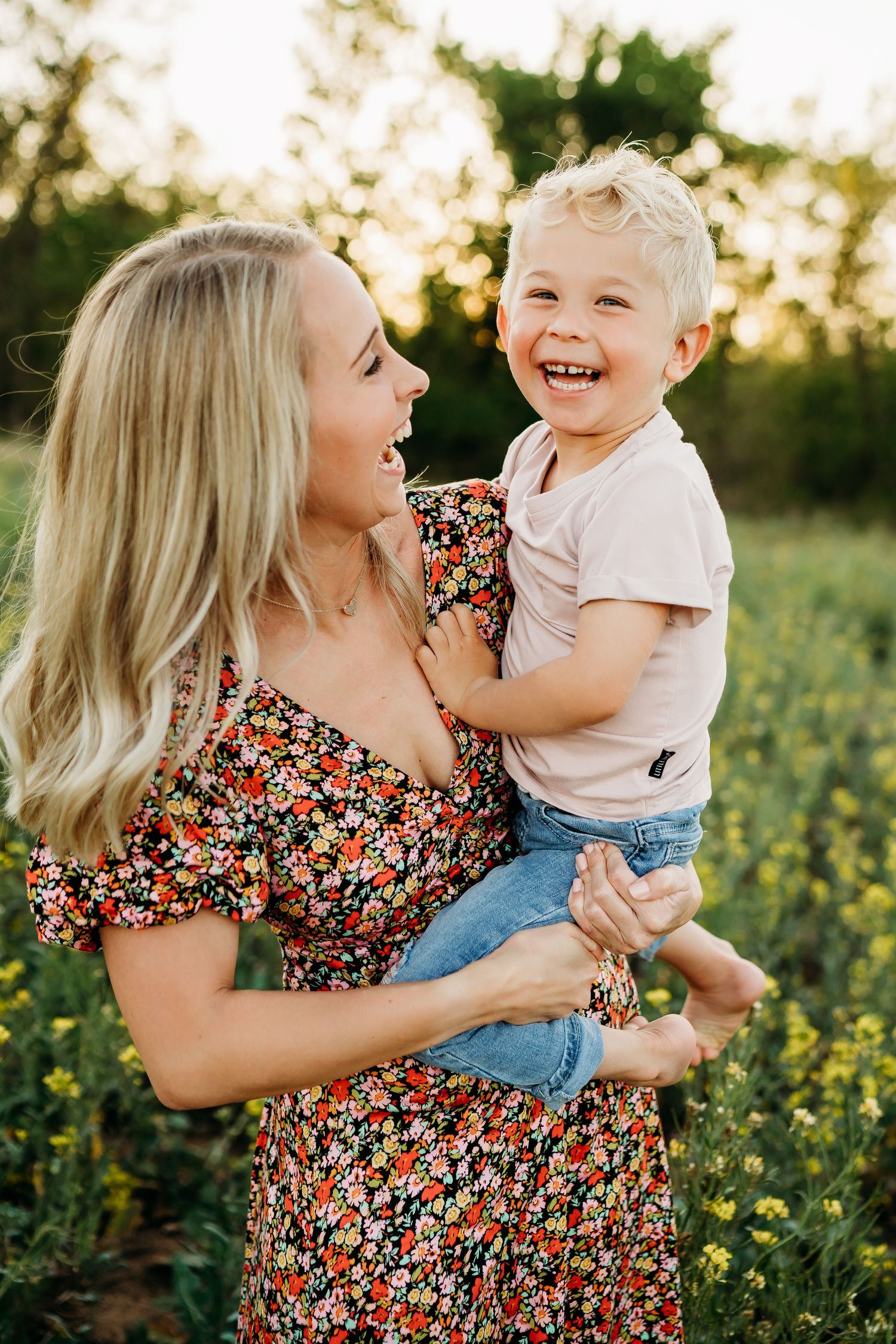 Joyful interaction between parent and child in blooming yellow flower field.