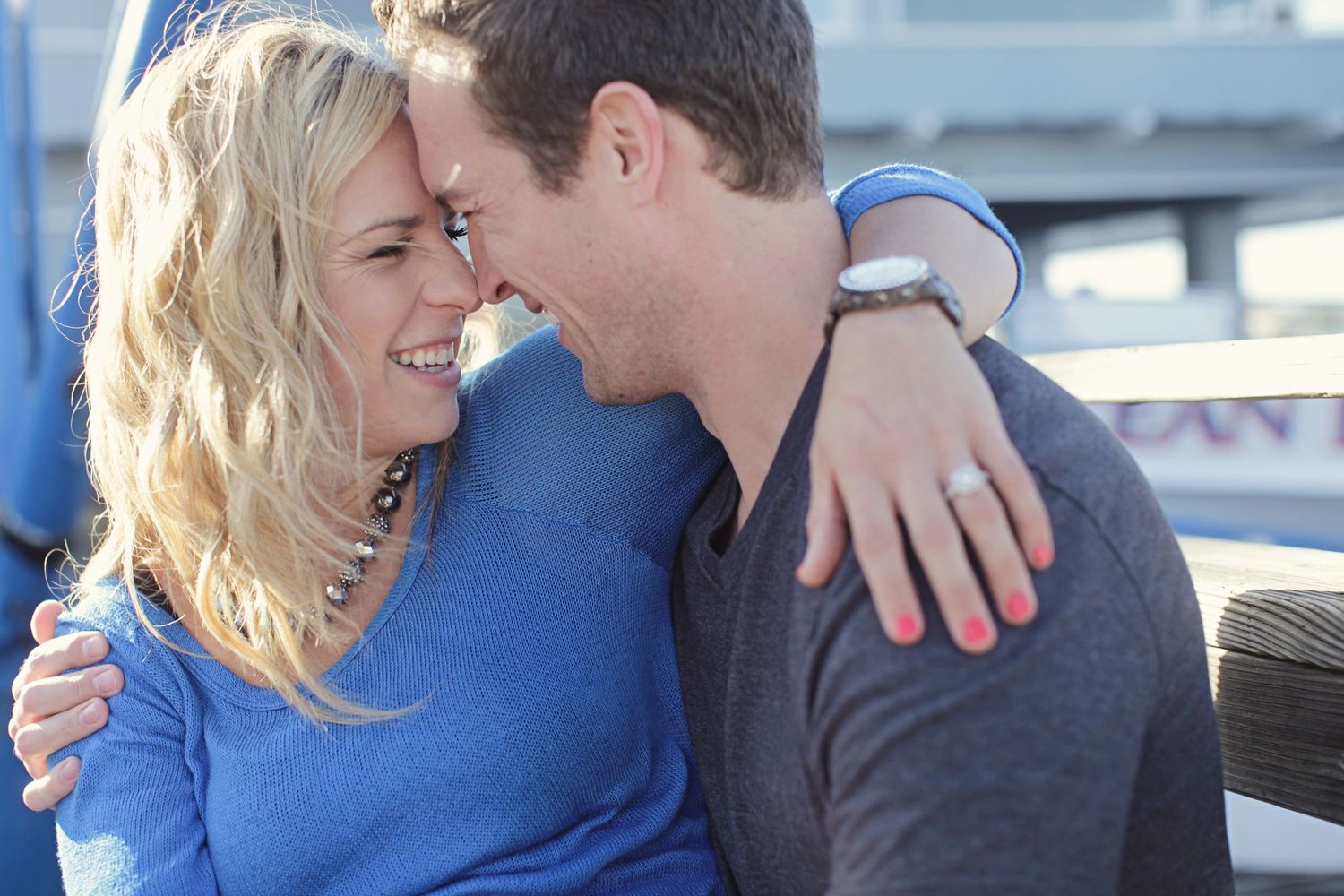 Couple sharing an intimate laughing moment while embracing outdoors.