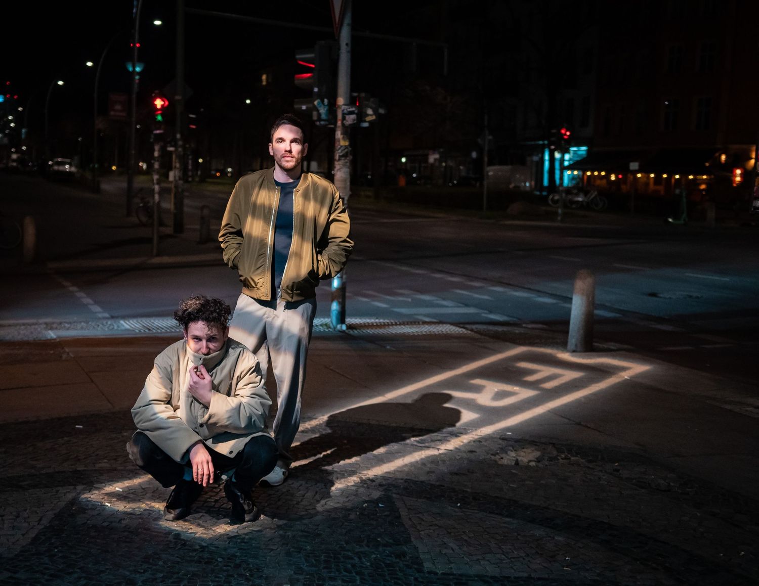 Late night urban street photography with figures posed under ambient lighting.