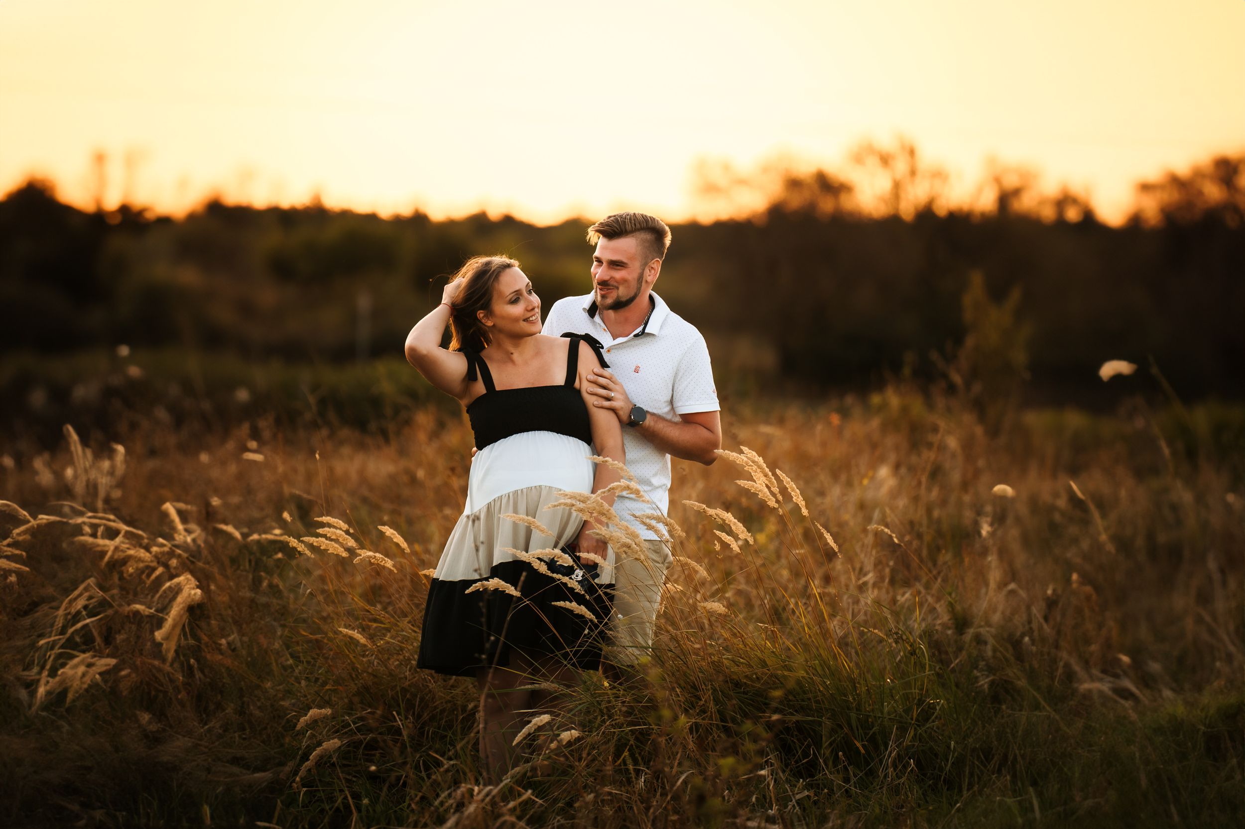 A romantic sunset moment in a golden field of tall grass at dusk.