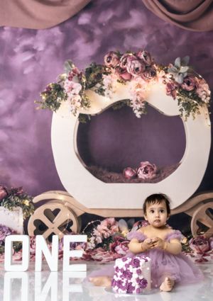 Elegant floral arch setup with purple backdrop and white carriage prop for special occasion photos.