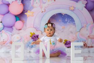 Magical purple and pink balloon arch with fantasy-themed decorations and glowing letters.
