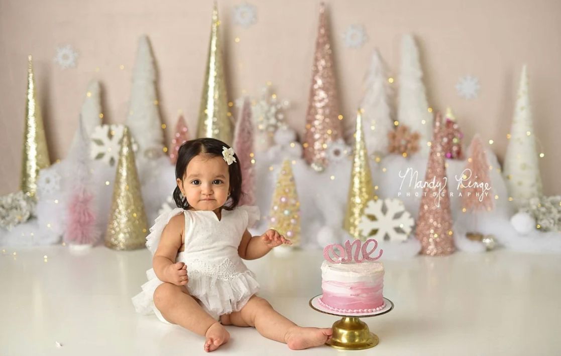 Pink and gold birthday party decorations with cake and festive details for a first birthday celebration.