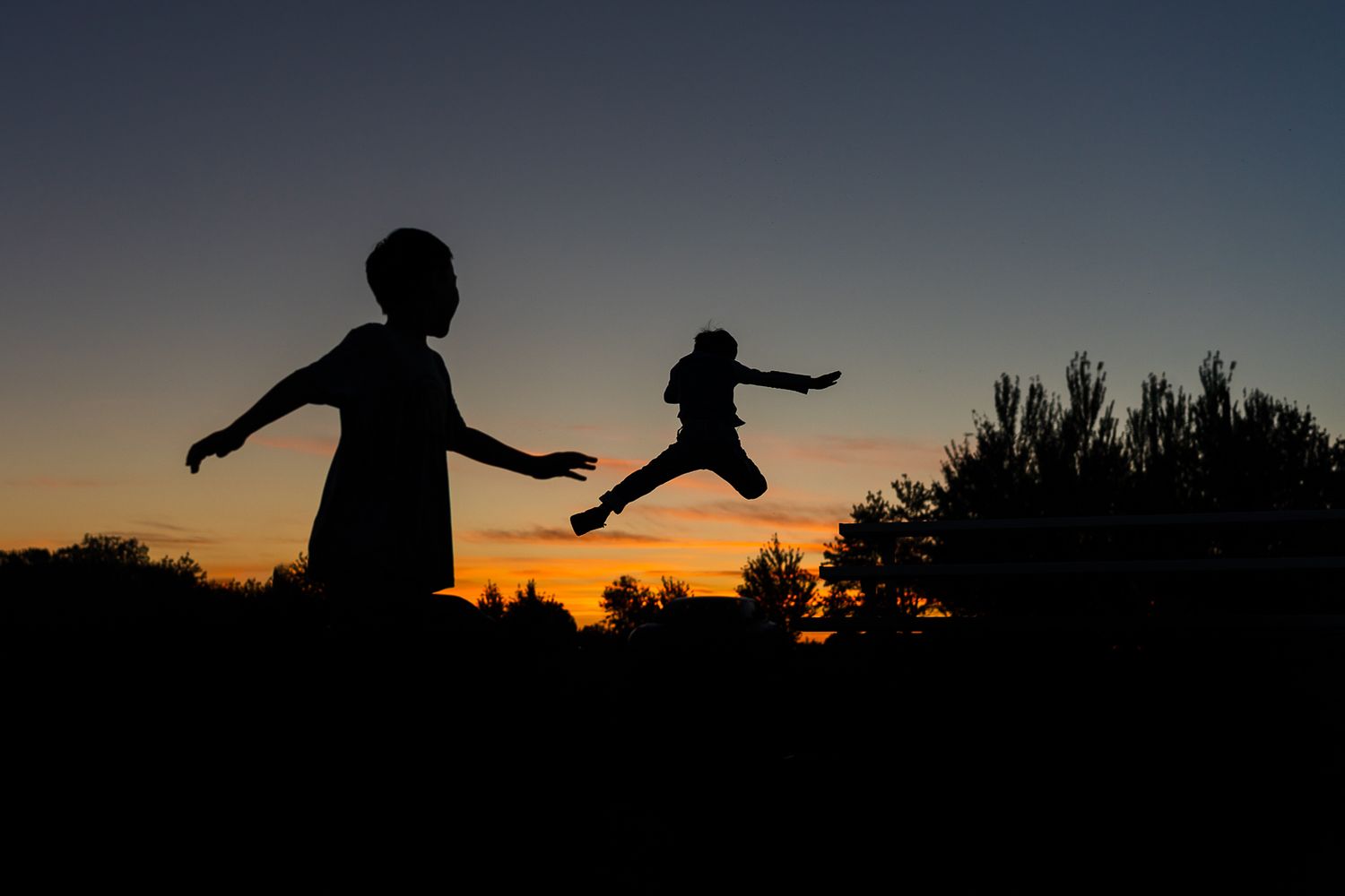 Boys jumping off the bleachers in Redmond during a family photo session