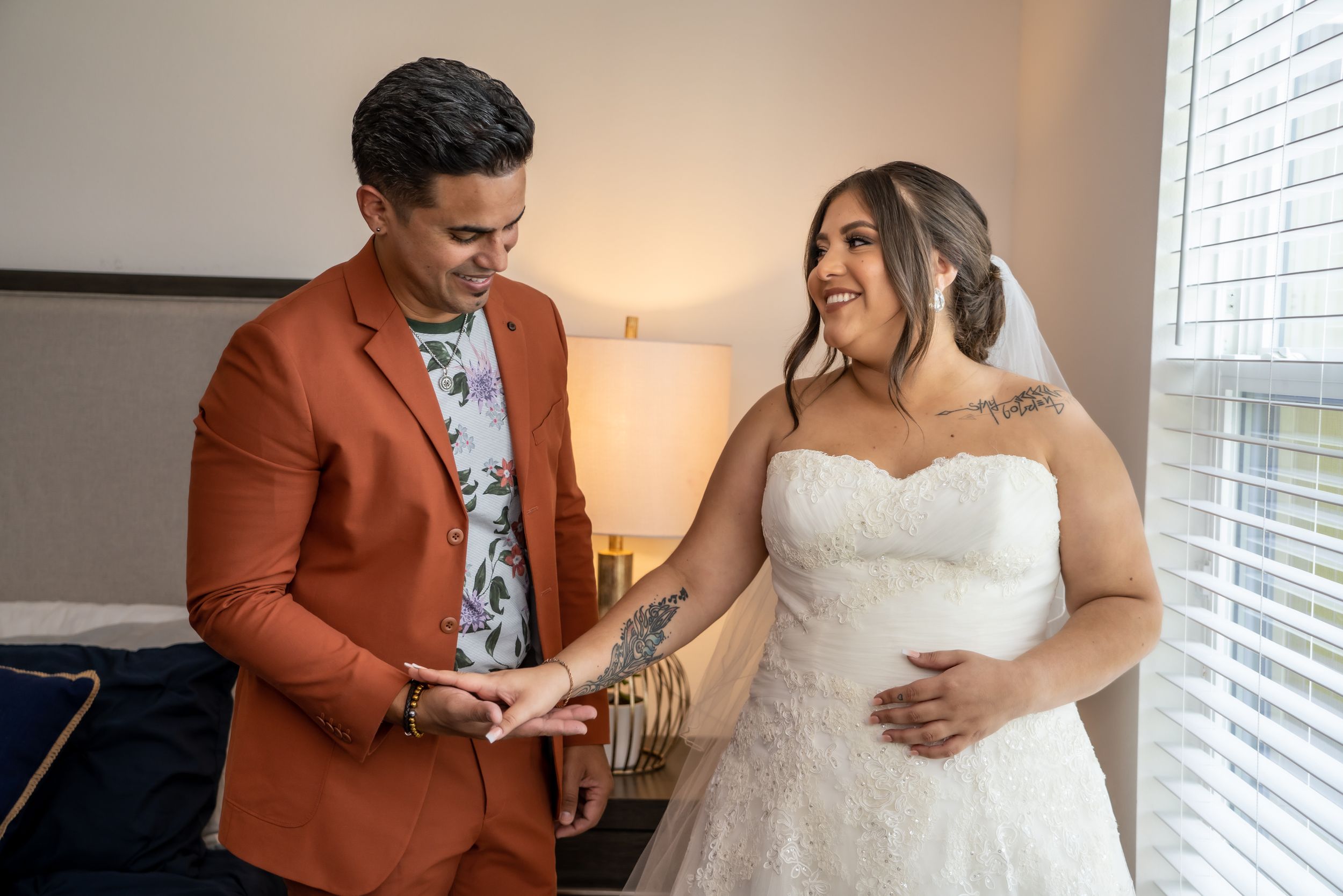 A couple shares a tender moment while getting ready in formal wedding attire.