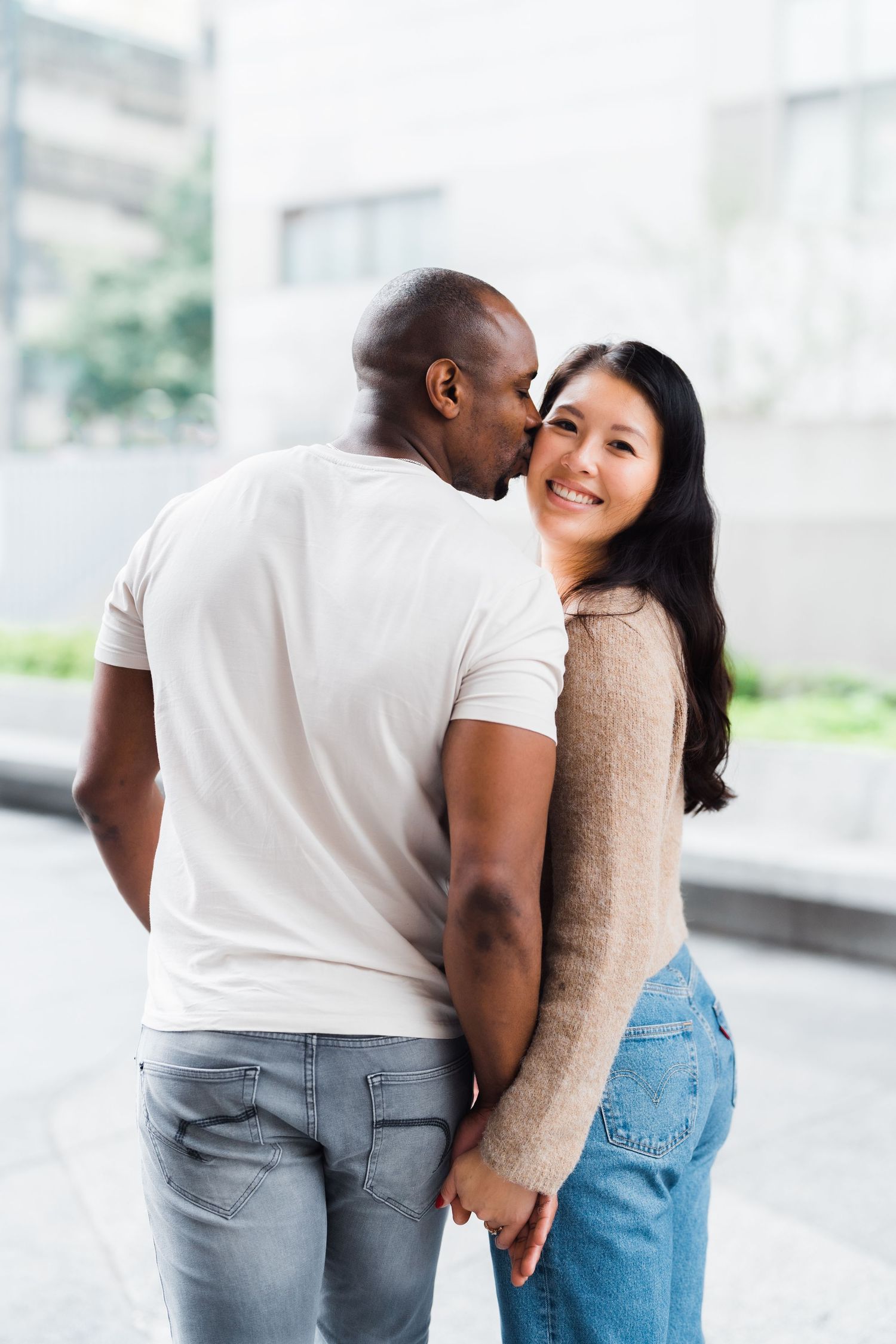 Affectionate couple sharing tender moment together in casual outfits.