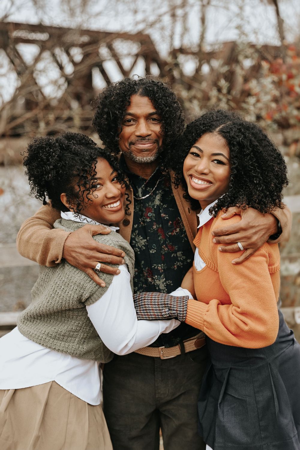 A candid moment showing friends embracing and laughing together in cozy winter outfits.