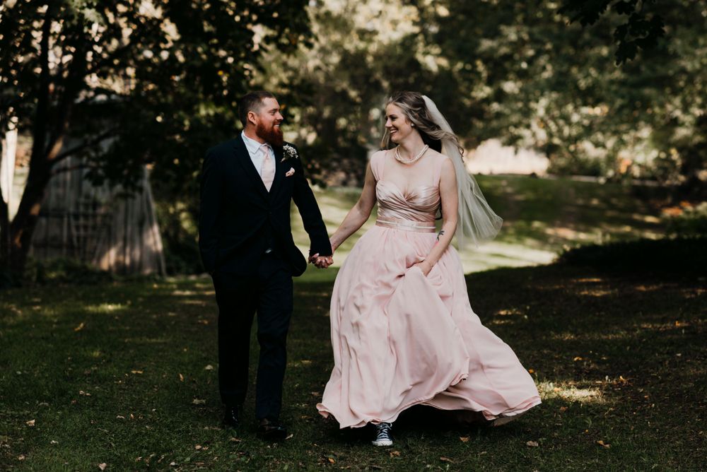 A couple dancing outdoors in formal wear, with the dress flowing in the breeze.