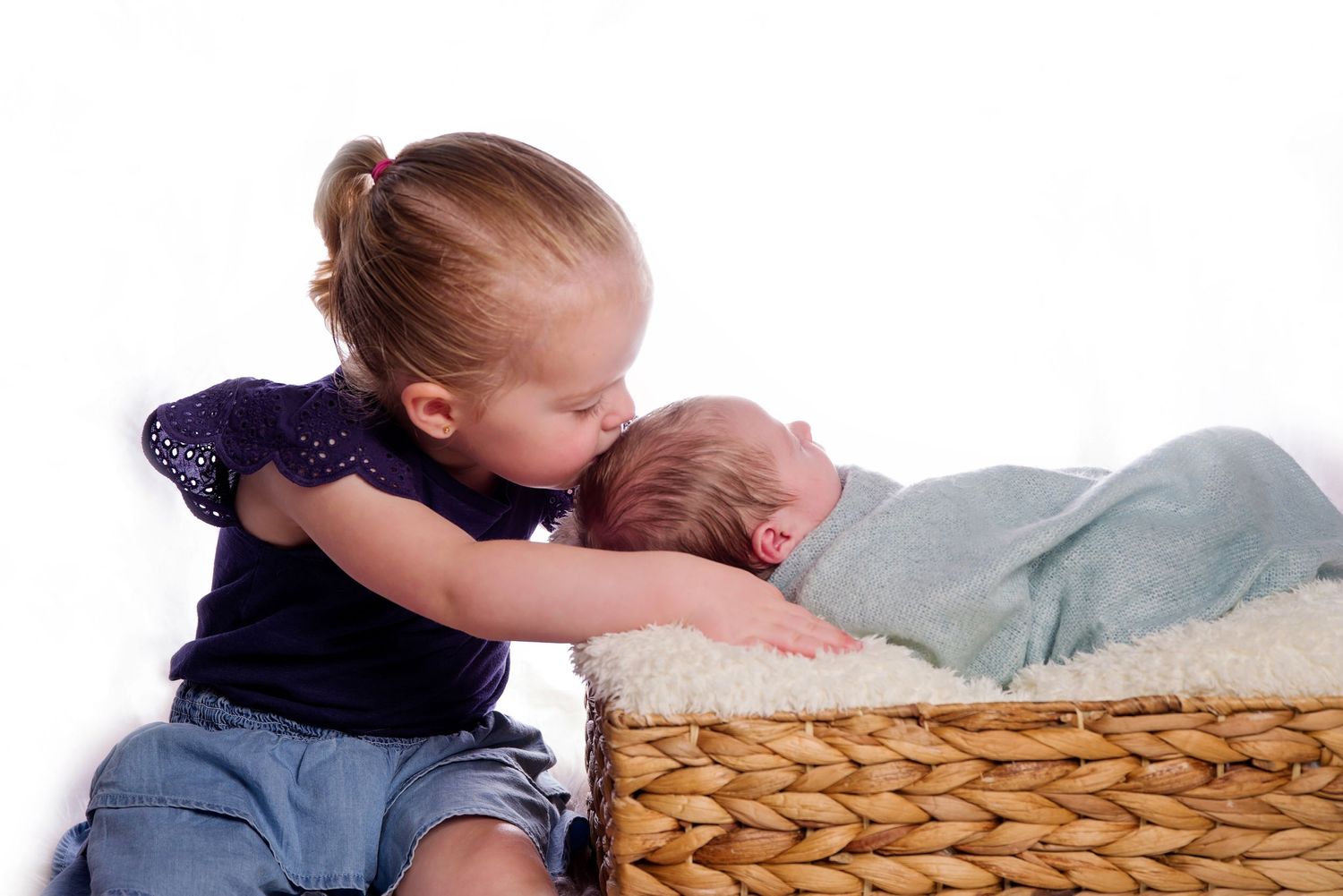 toddler kissing baby brother
