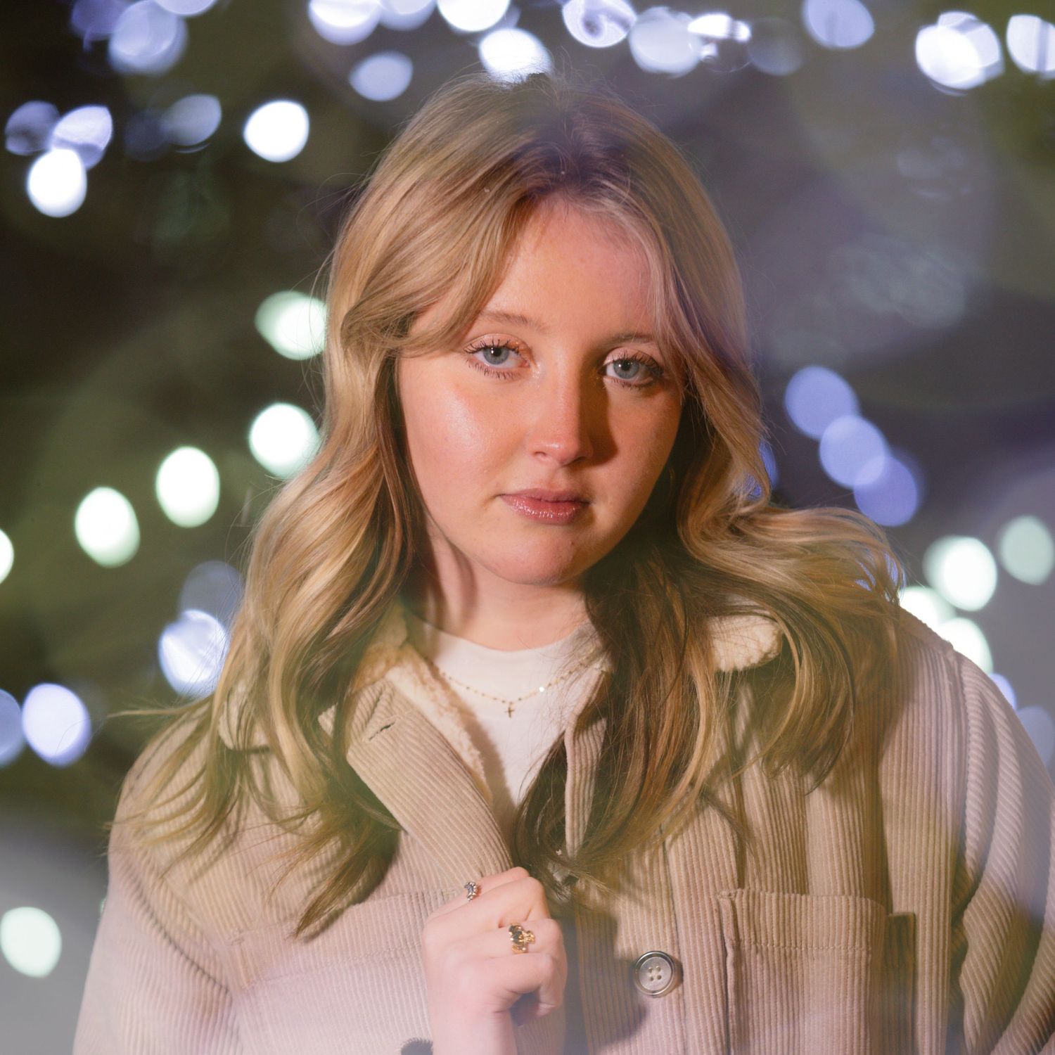 Portrait with soft bokeh lighting effects and cream colored sweater.