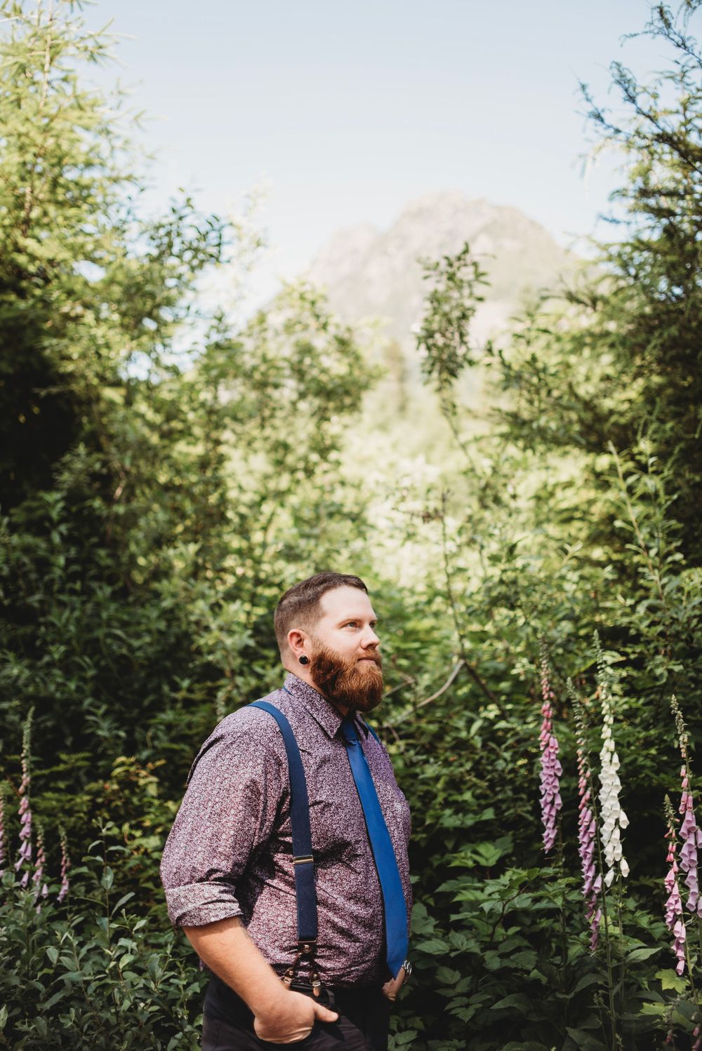 Groom stands waiting to see his bride for the first time in the mountains at his elopement