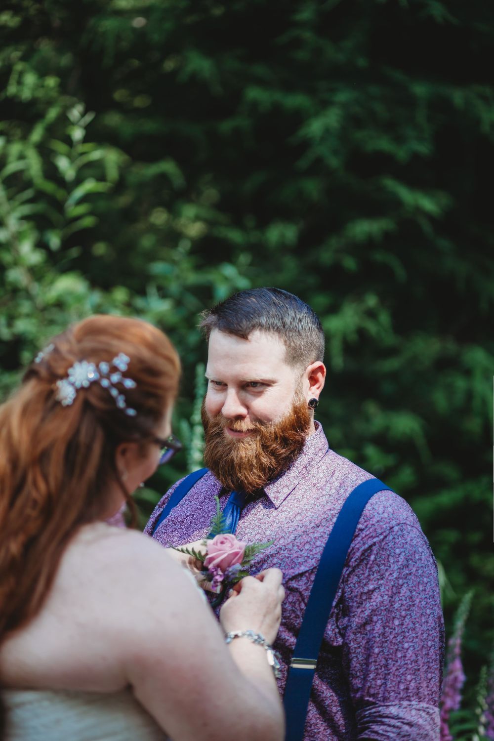 Bride pins grooms flowers to his pocket before their wedding