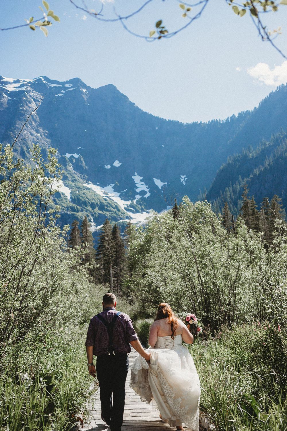 Bride and groom walk down a boardwalk trail after their ceremony