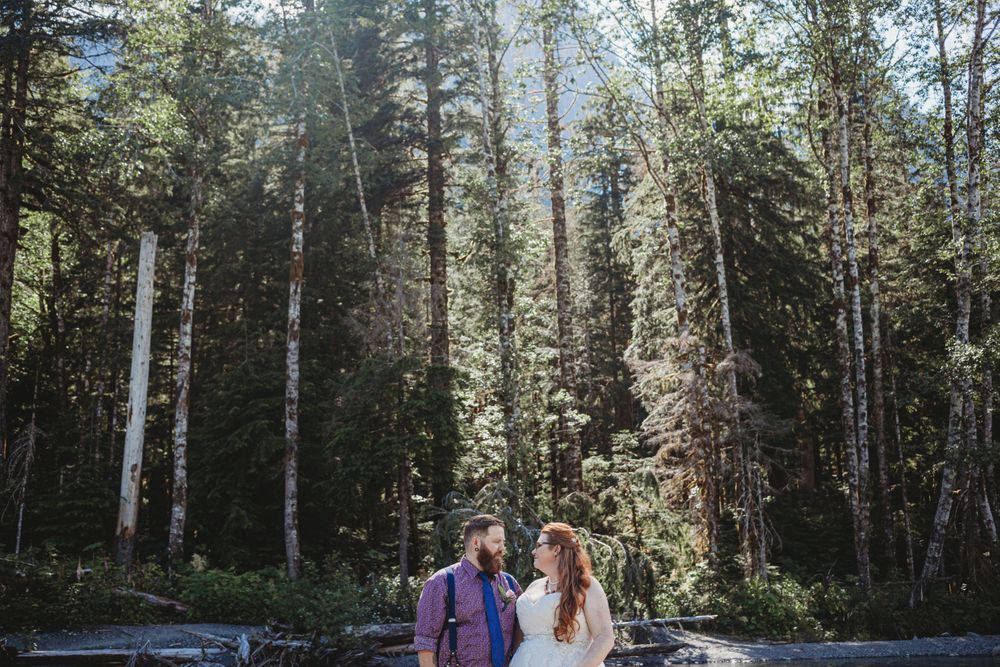 Bride and groom look at each other in the trees at their elopement