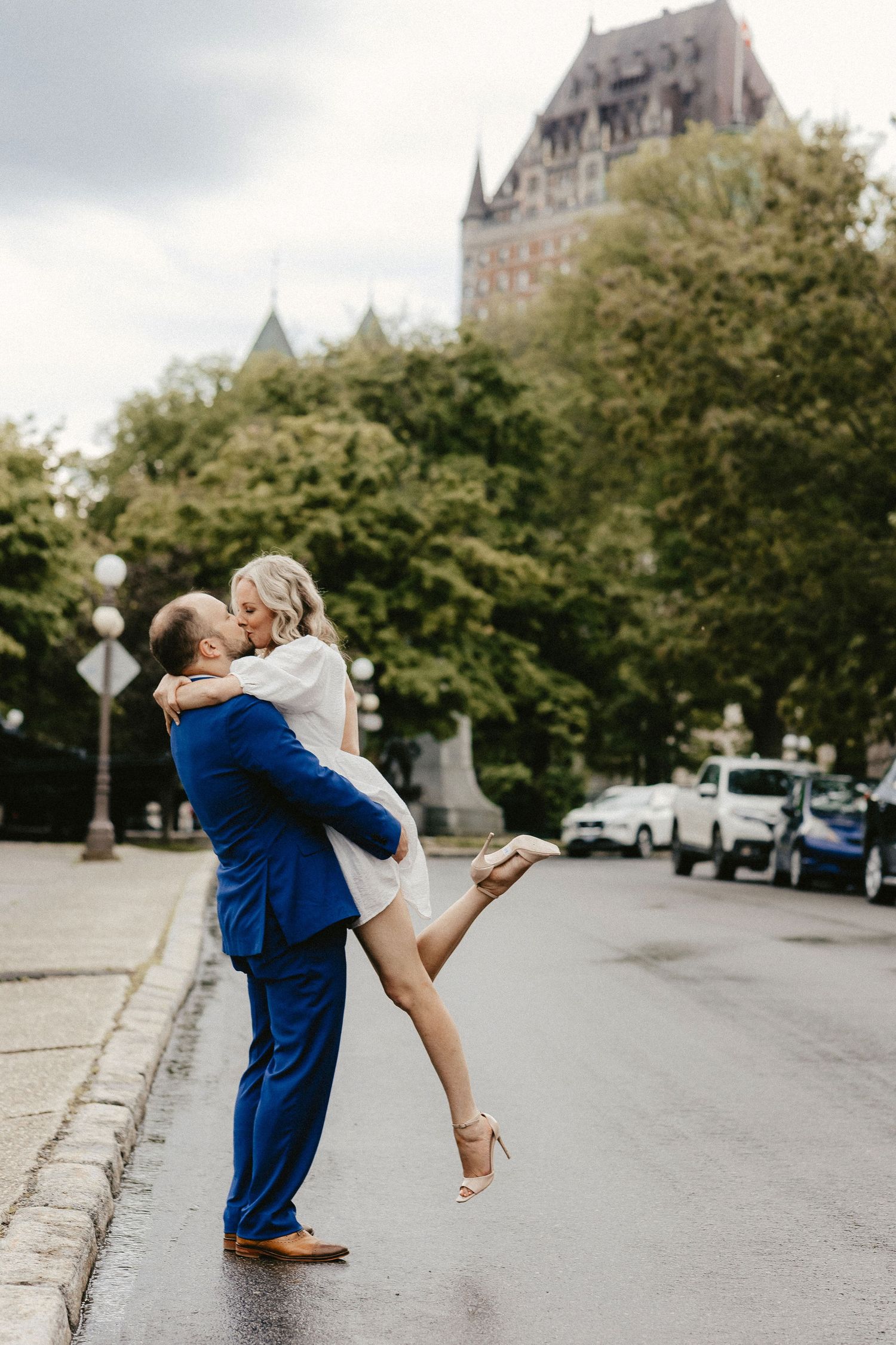 A joyful lift pose captured in front of the majestic Chateau Frontenac.