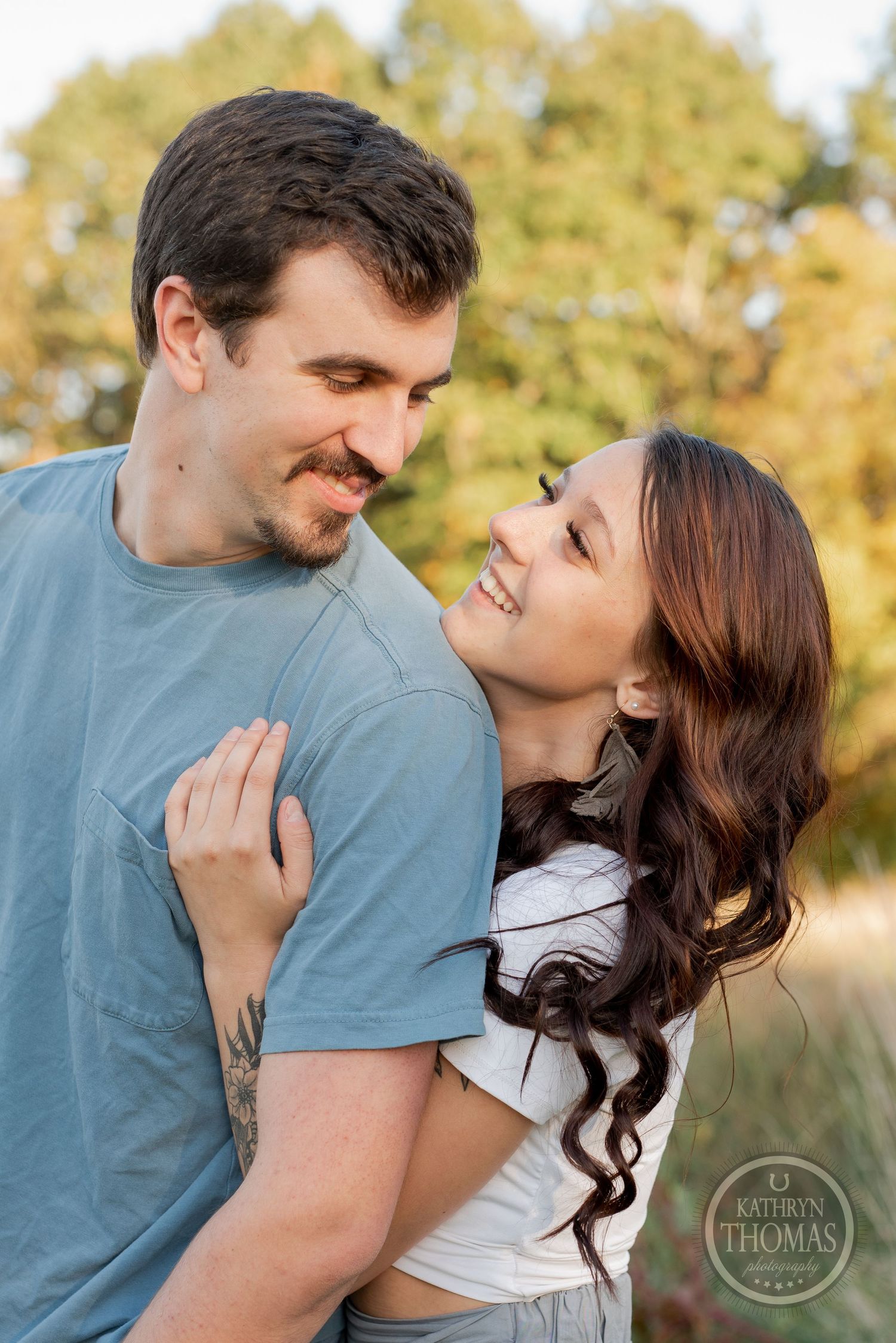 A tender moment between two people in casual attire against a golden sunset background.