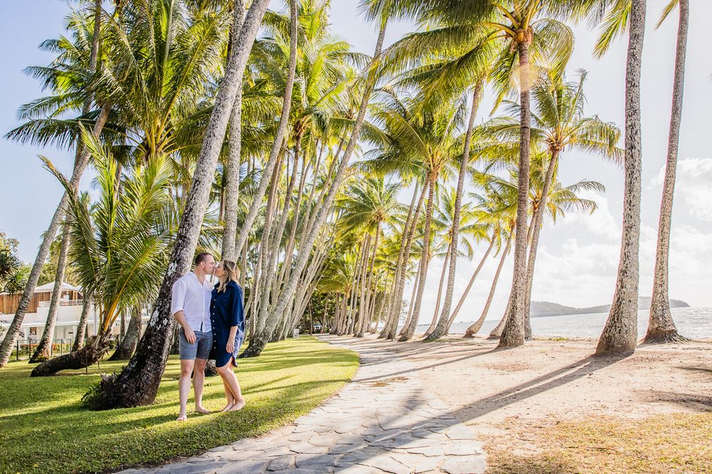 Couple kissing under palm trees at Palm Cove Cairns