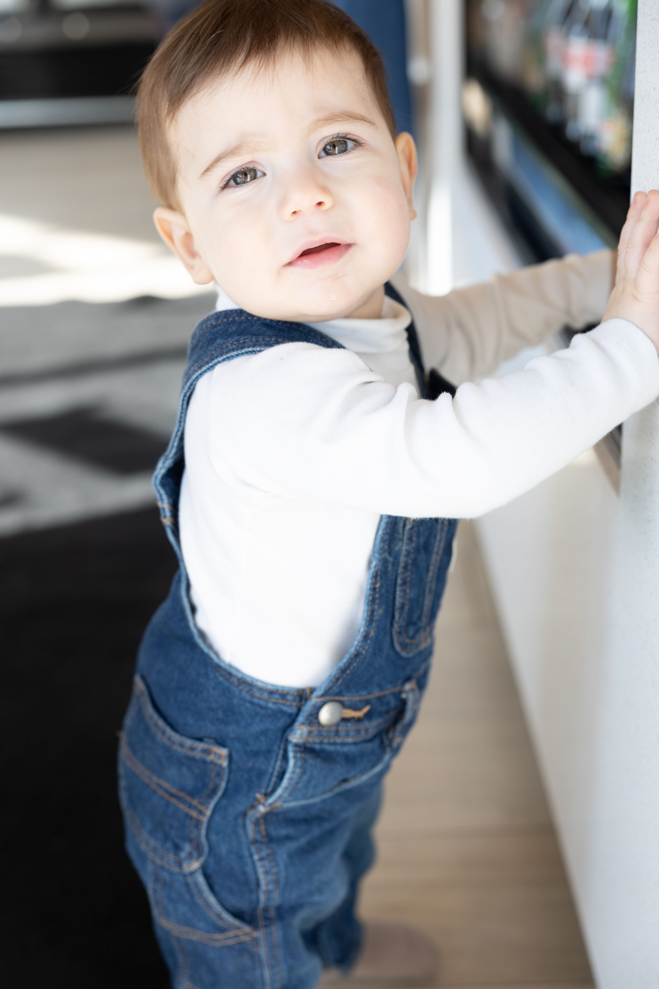 Baby in overalls looking up