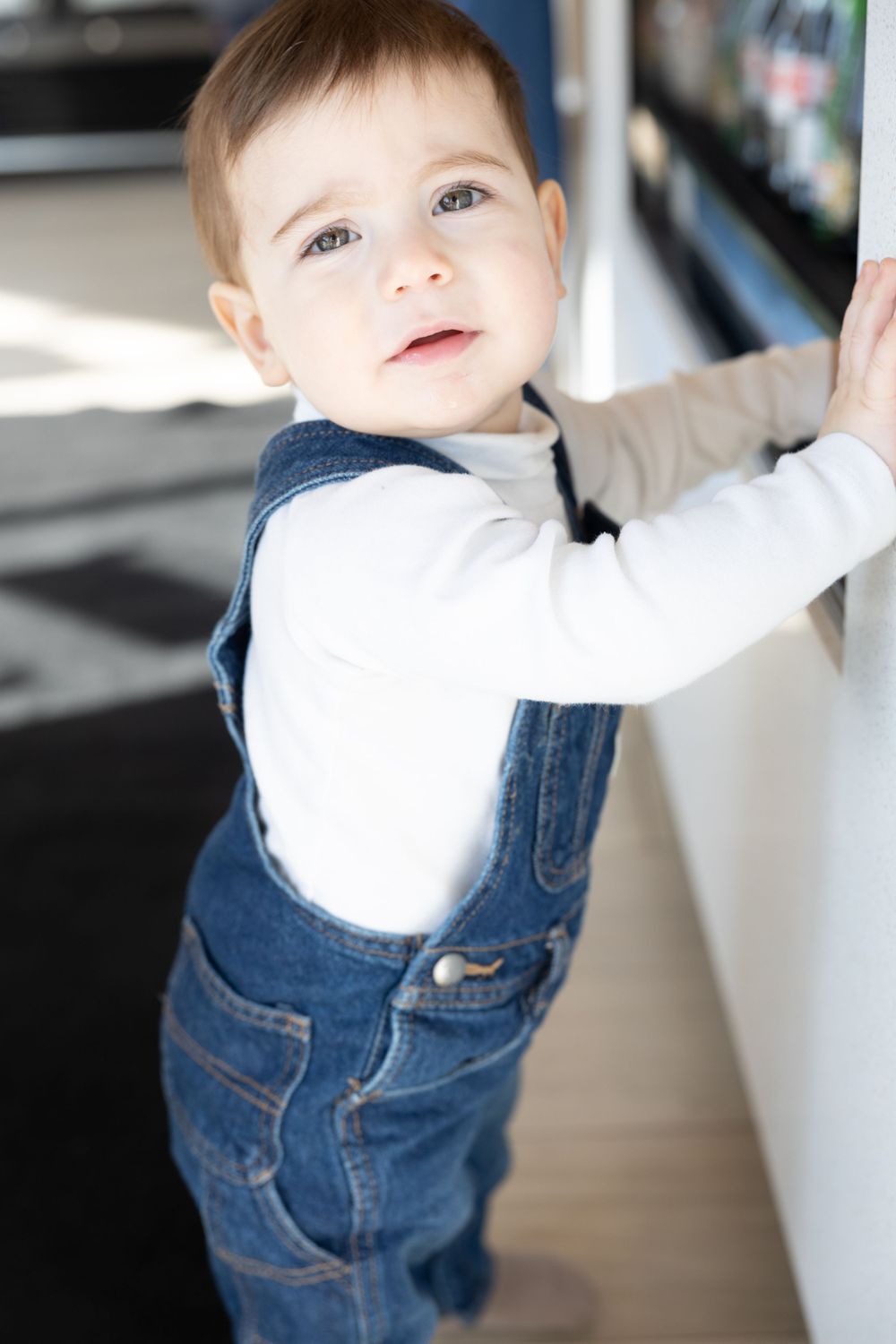 Baby in overalls looking up