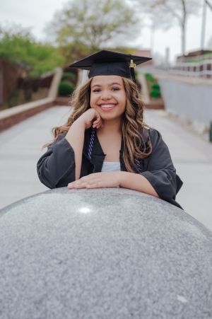 Slippery Rock University senior shines with a big smile, exuding joy and accomplishment on the vibrant campus grounds.