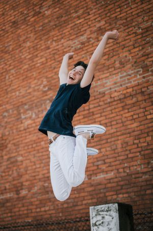 St. Ignatius senior captures exuberance in Downtown Cleveland, leaping joyfully with arms raised and a beaming smile.