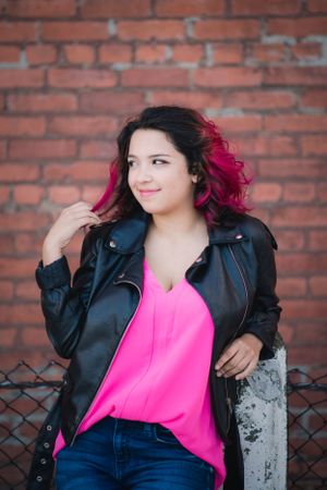 North High School senior radiates joy in Downtown Cleveland, twirling her hair with a soft smile.