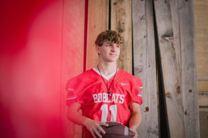 Norwayne High School senior showcases team pride in Akron, Ohio, clutching football in his football jersey.