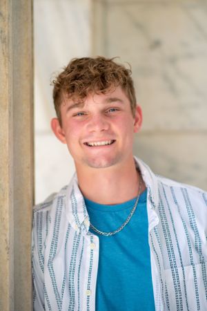 Male senior exudes charm during Cleveland Museum of Art senior session, smiling brightly at the camera.