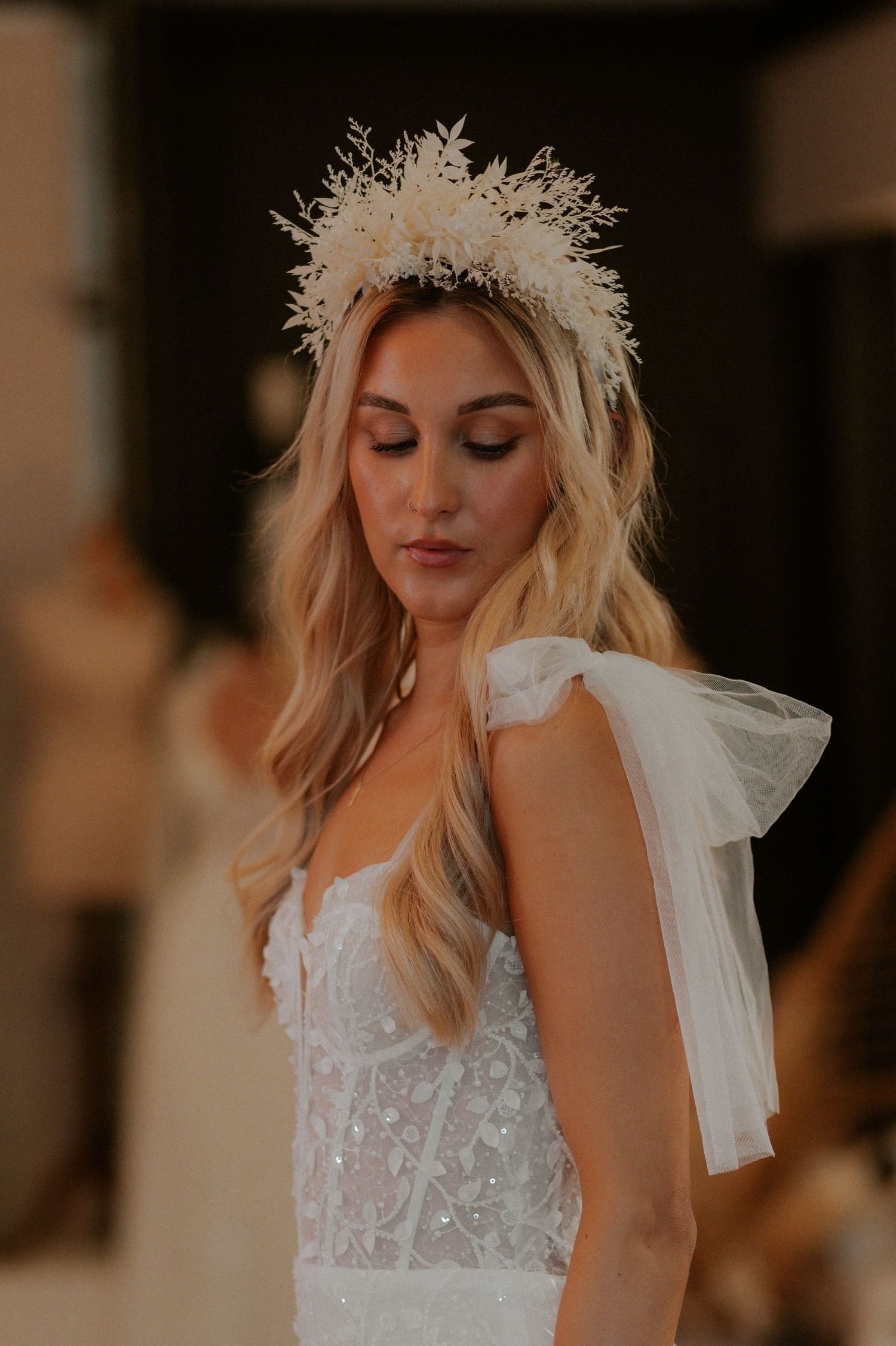 Ethereal bridal look featuring delicate lace gown and intricate white crown headpiece.