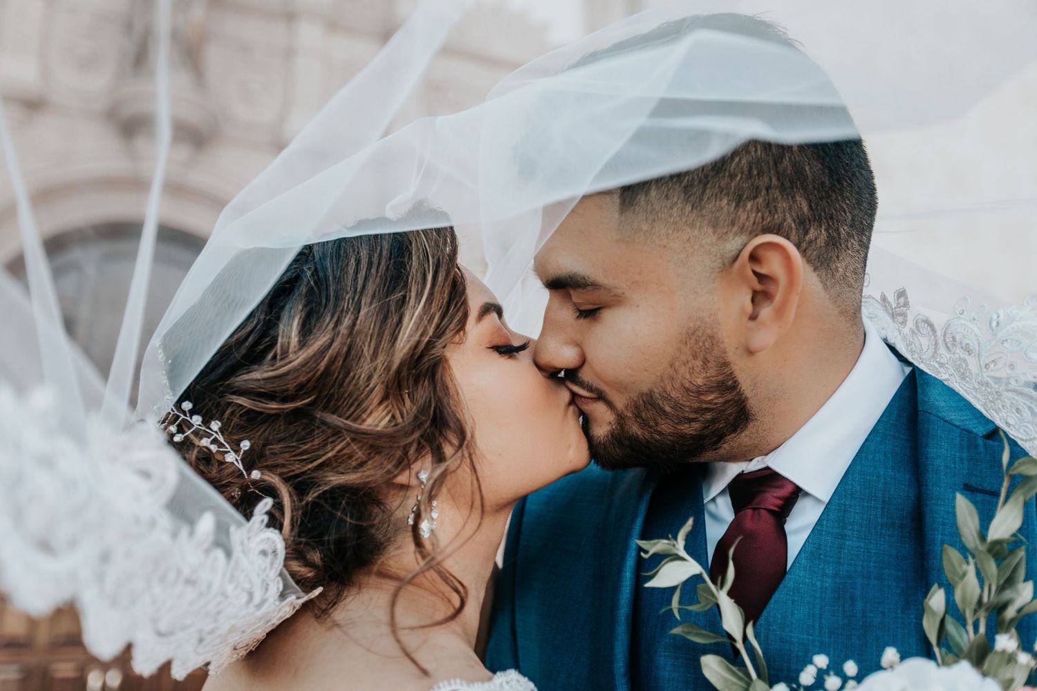 Intimate Tucson wedding portrait of a bride and groom kissing under a shared veil.