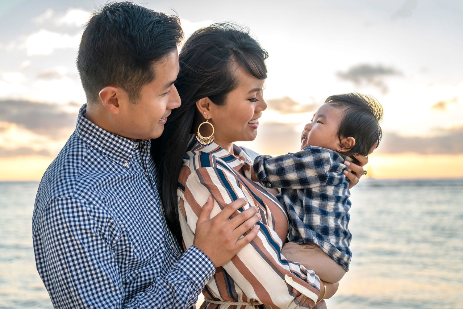 Family shares a tender moment together at sunset by the ocean. Family Photography Hawaii