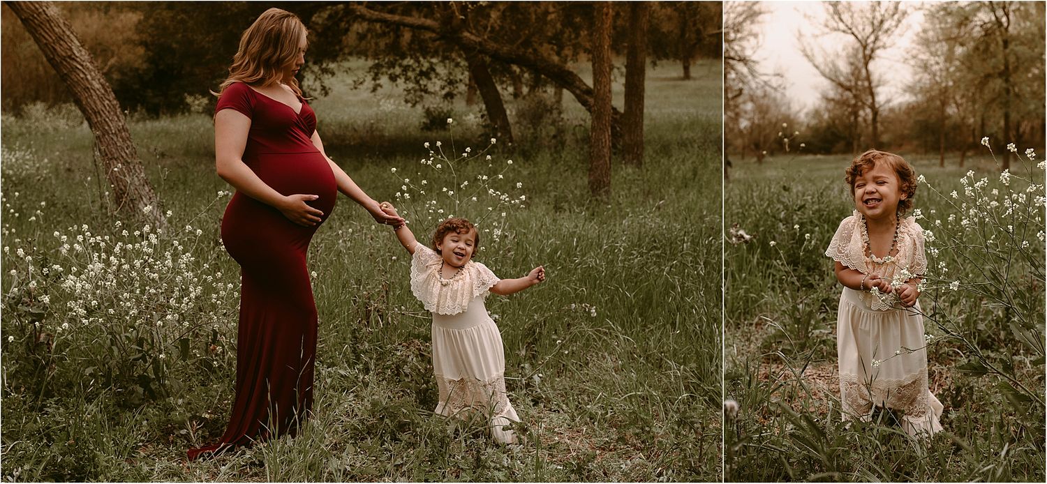 Mother and child hold hands while walking through a spring meadow filled with white flowers.