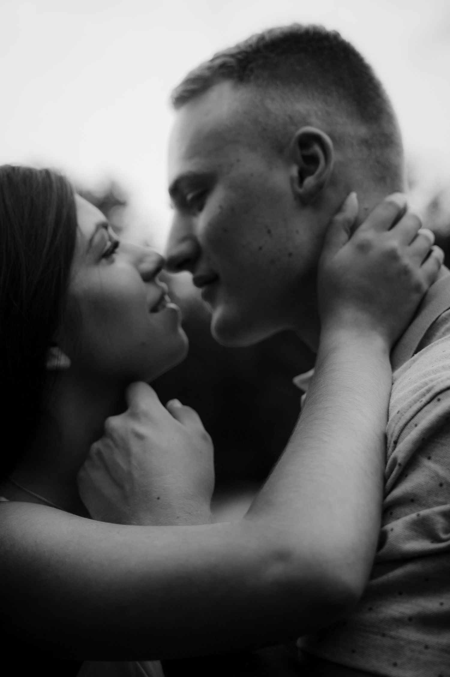 Intimate black and white portrait of couple in tender embrace.