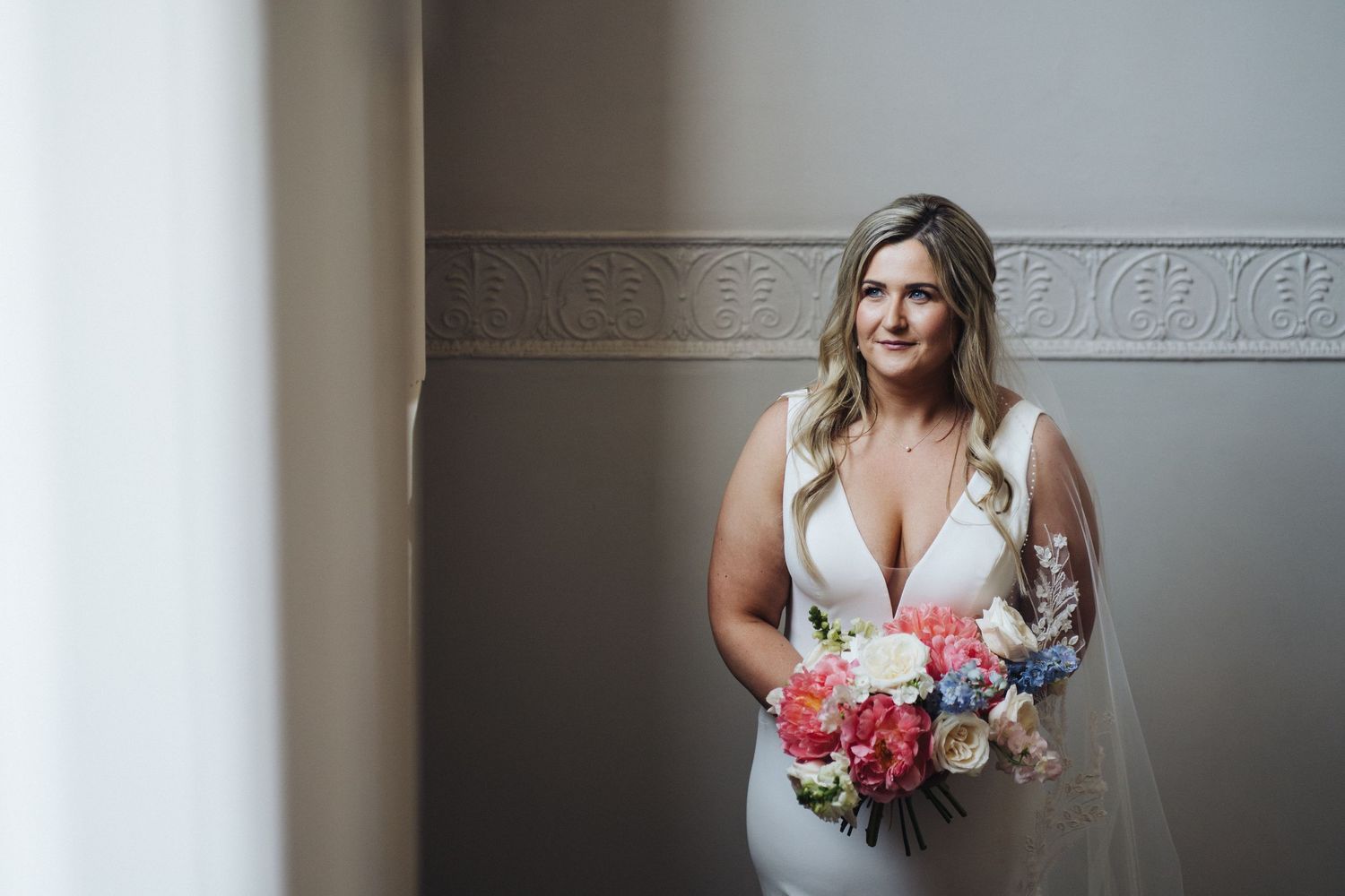 A bridal portrait showing a beautiful bouquet of pink and coral flowers.