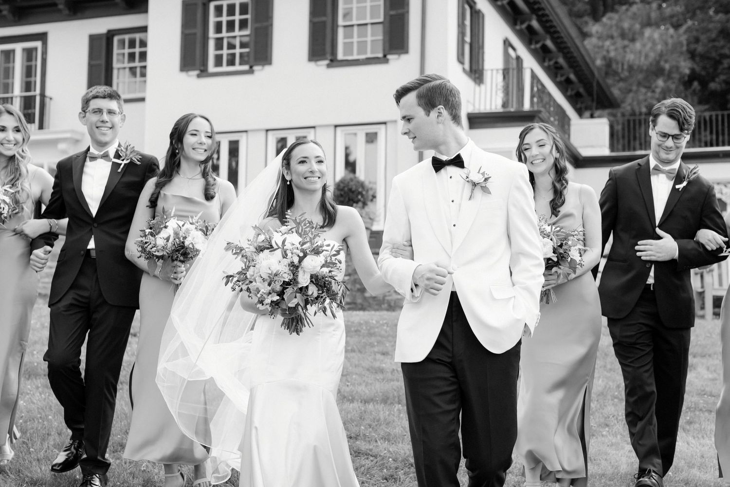 full wedding party walking down hill at The Willows in Villanova