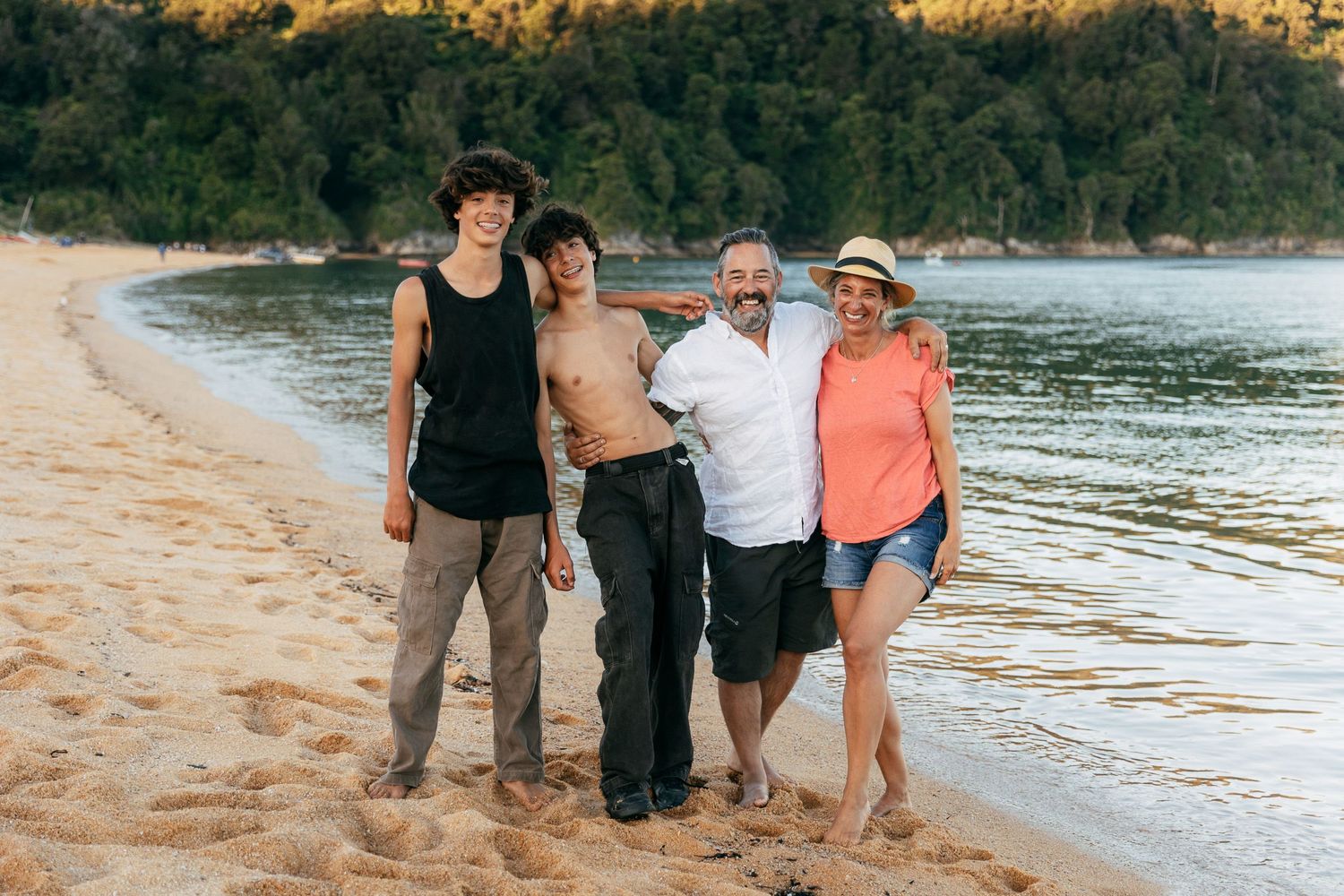 parents and teenage twins standing on beach at Totaranui