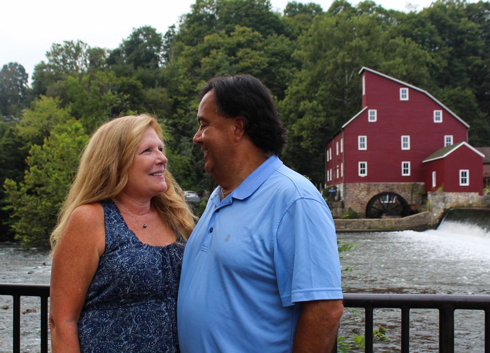 Couple enjoying view of the historic Red Mill Museum and waterfall in Clinton, New Jersey.