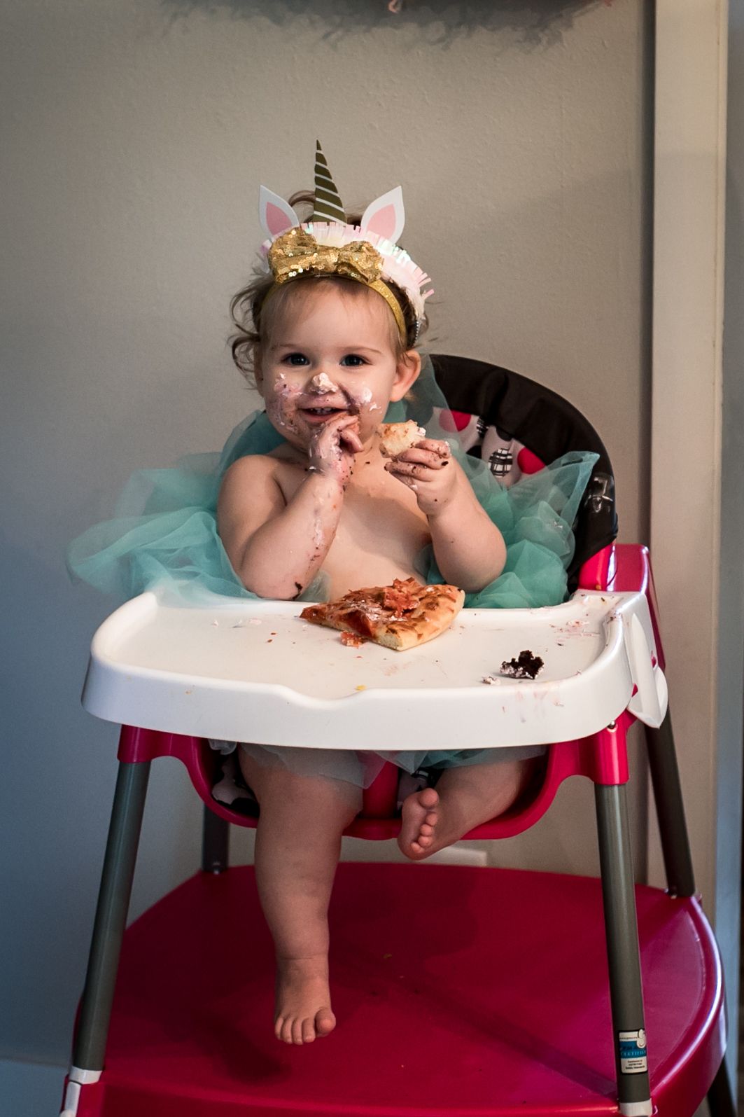 Baby girl eating pizza at her just birthday party in Sioux City, IA.