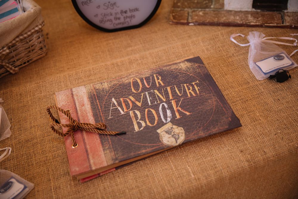 Vintage-style adventure book with leather binding and heart detail on burlap surface.
